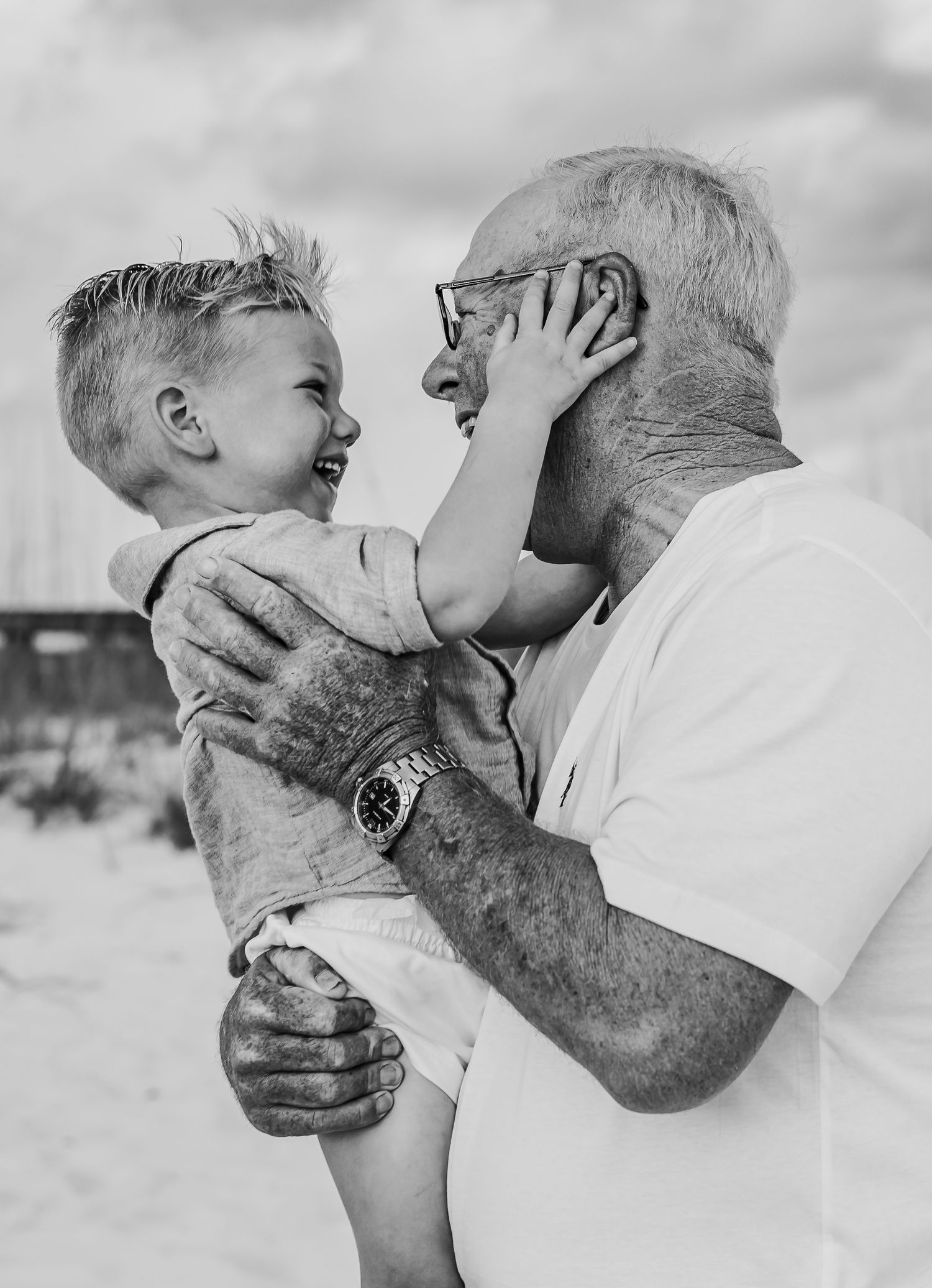 Black and white series of joyful moments between a young child and senior on a sunny day.