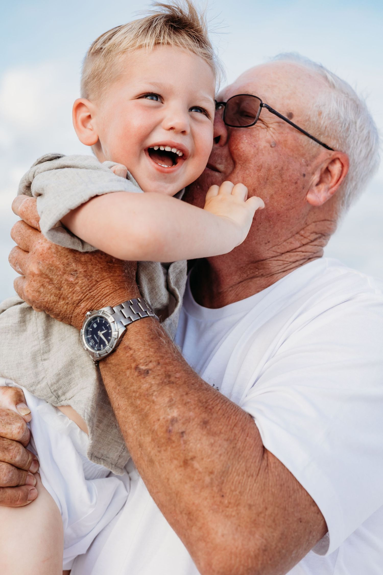 Close-up shots of playful interactions between a child and senior at the beach.