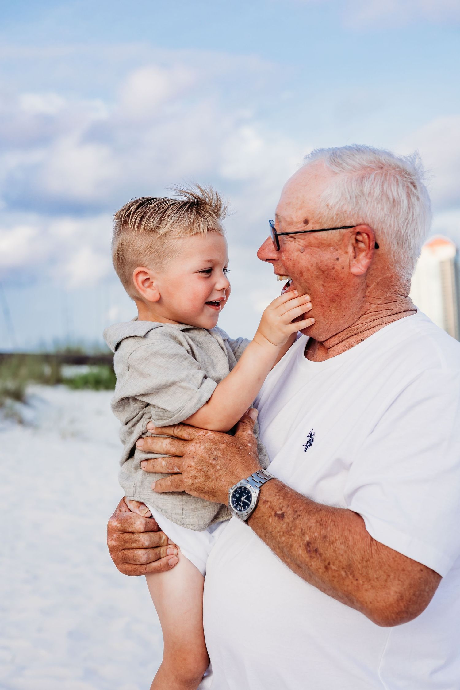 Candid moments of laughter and bonding between generations against a coastal backdrop.