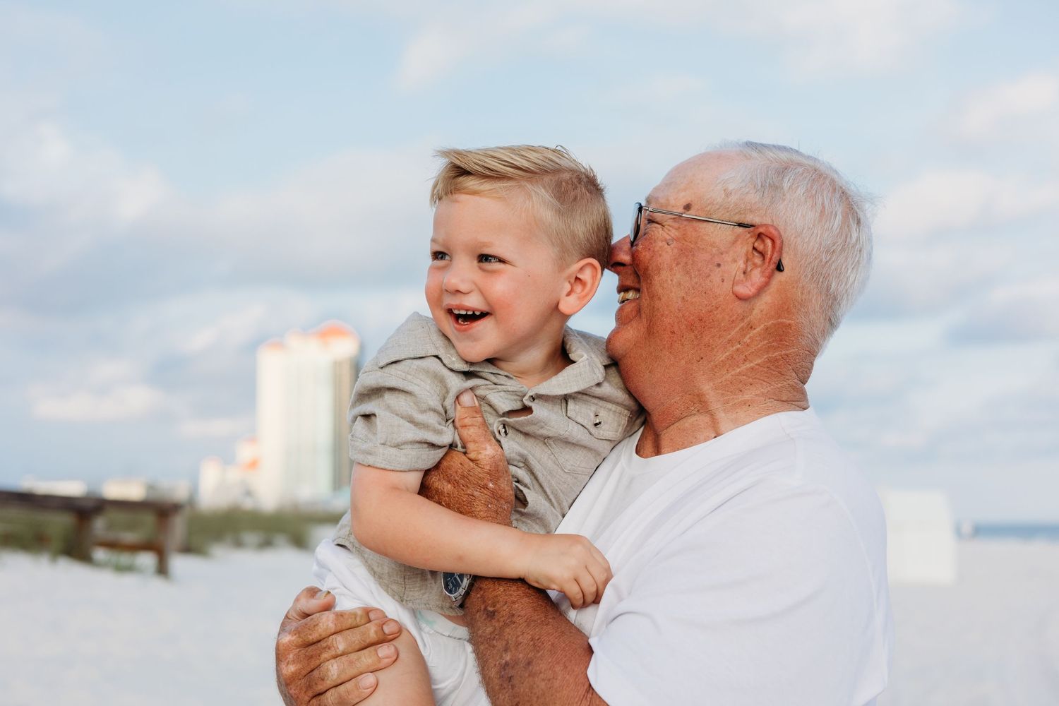 Natural expressions of happiness between family members at a sunny beach location.