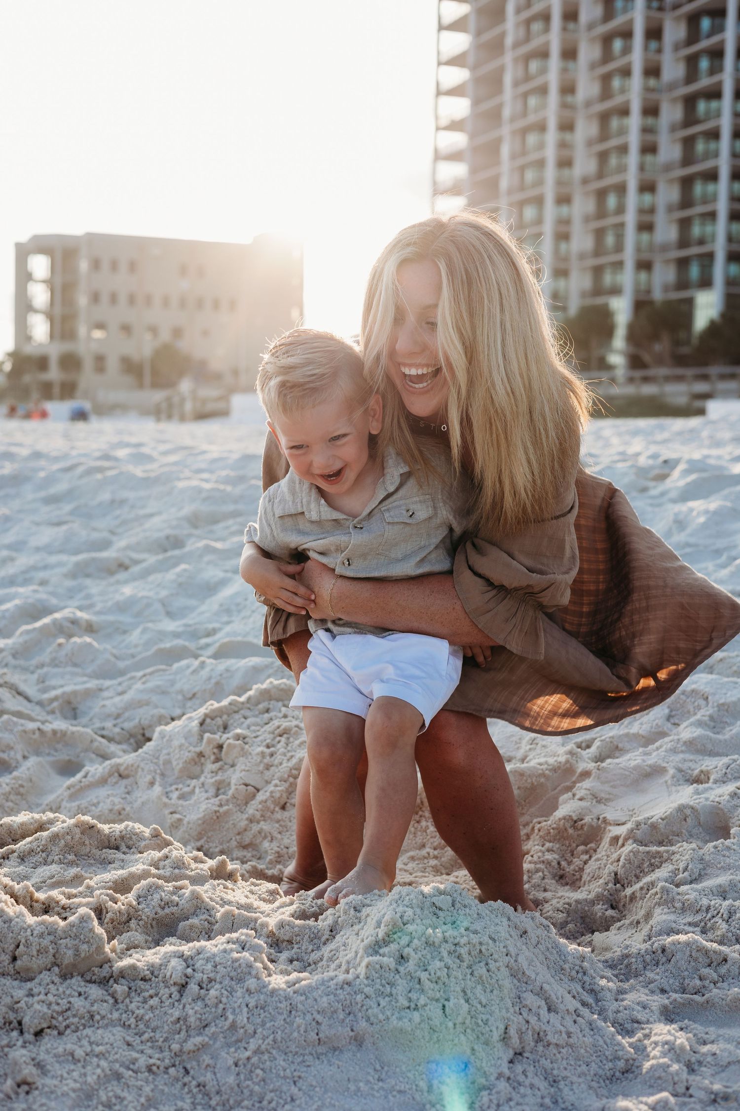 Heartwarming moments shared on a sandy beach with high-rise buildings in the background.