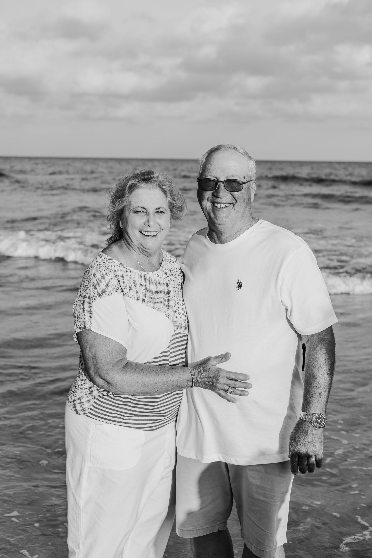 Black and white portrait of a happy senior couple enjoying time together by the ocean.