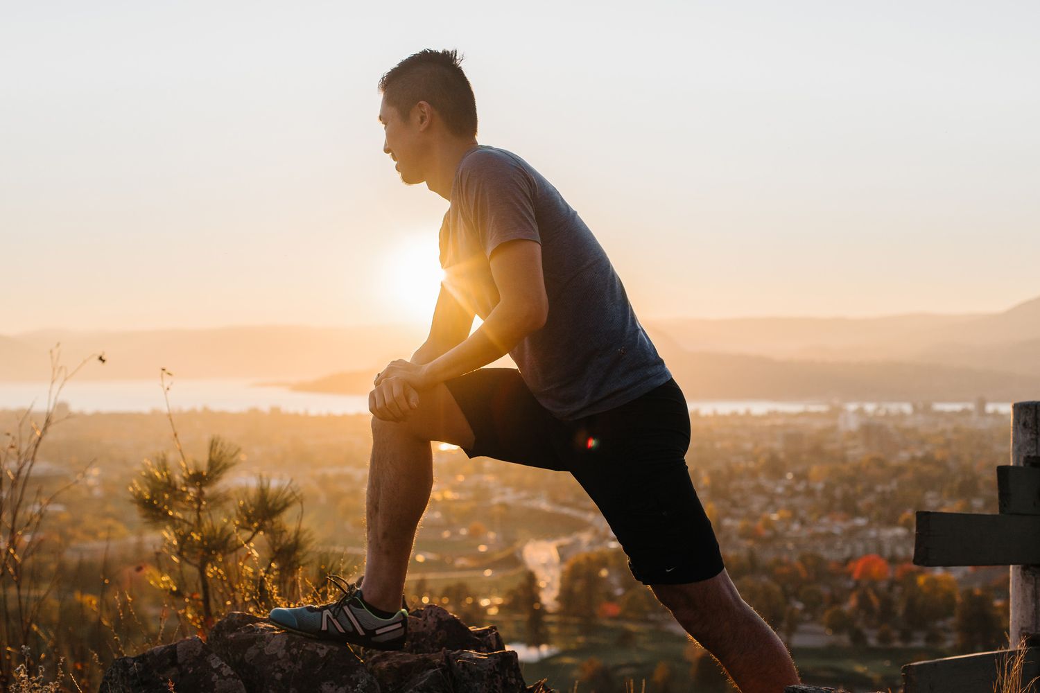 Person exercising at sunset with cityscape view in background.