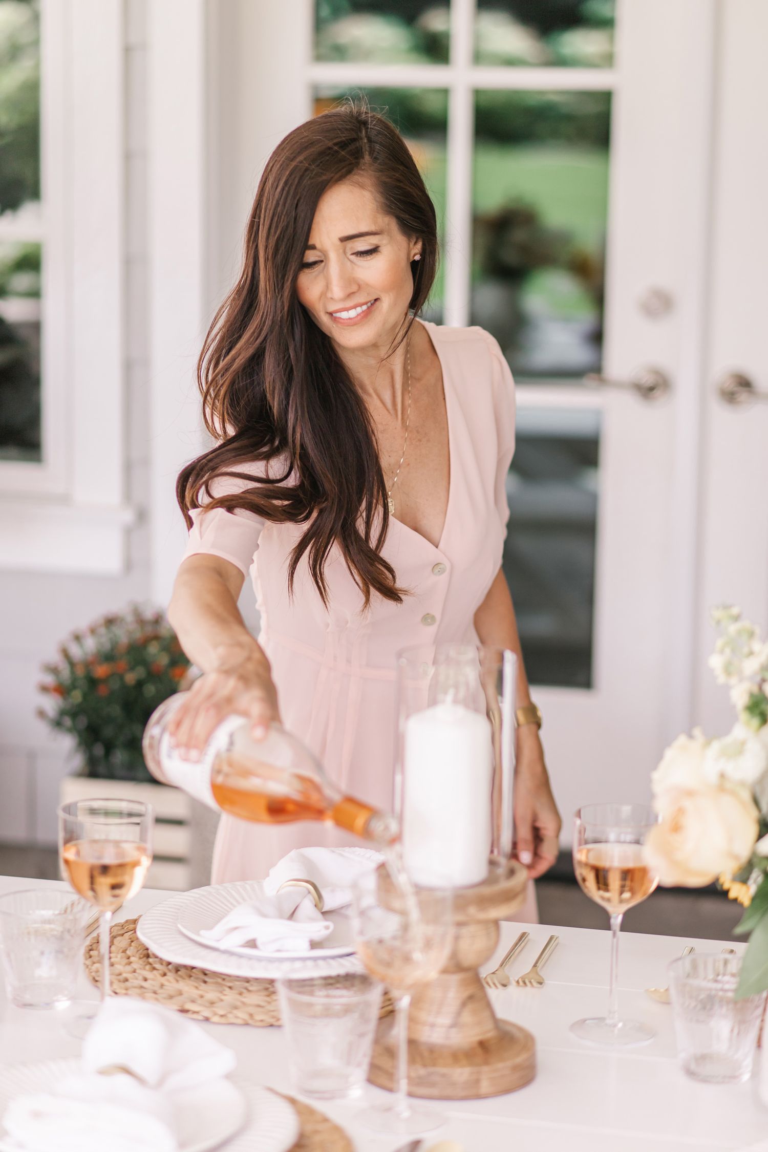 Light and airy dining scene with rose wine and table settings.