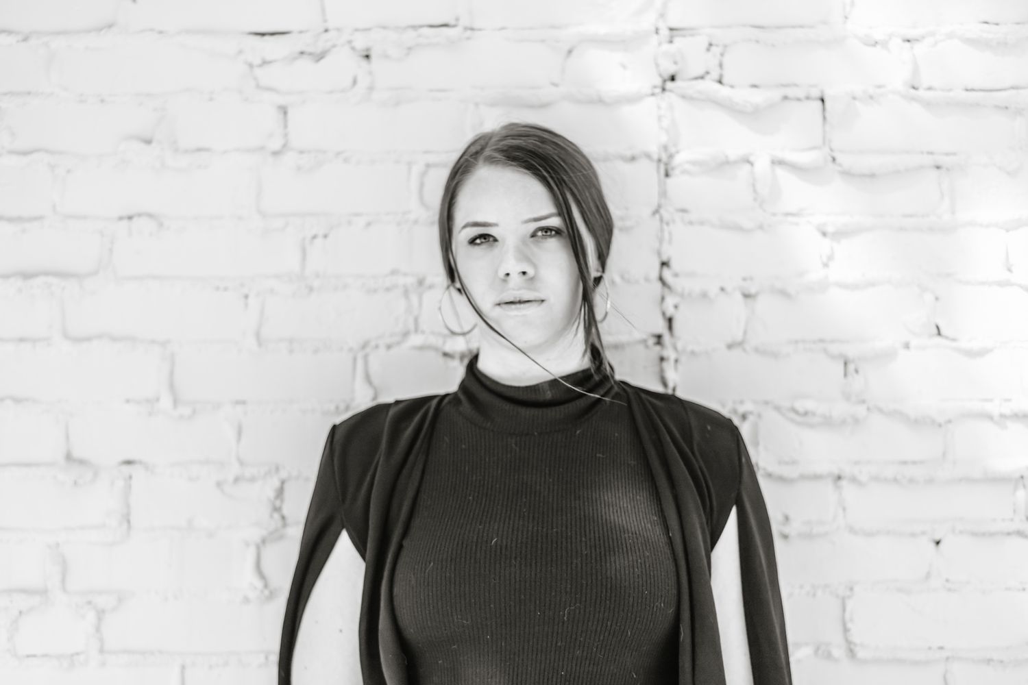 Portrait series against a white brick wall background.