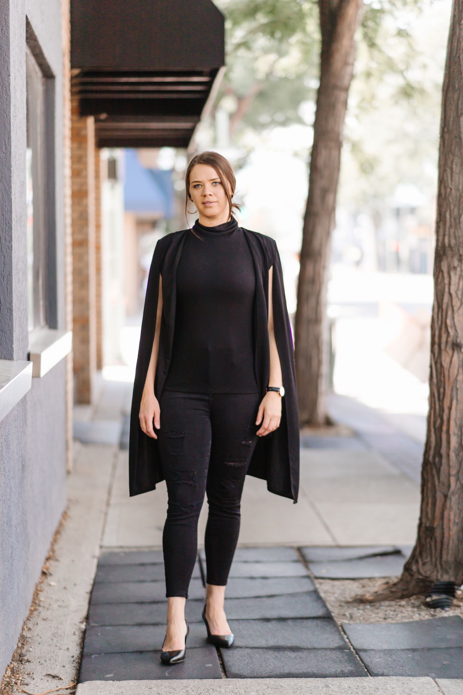 Professional fashion photography in an urban setting with columns and trees.