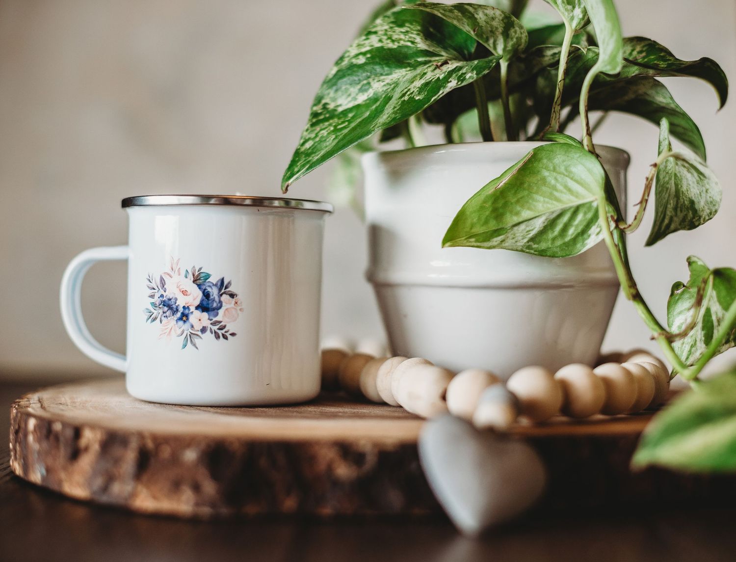 Minimalist home decor with houseplants and blue-detailed ceramic mug.