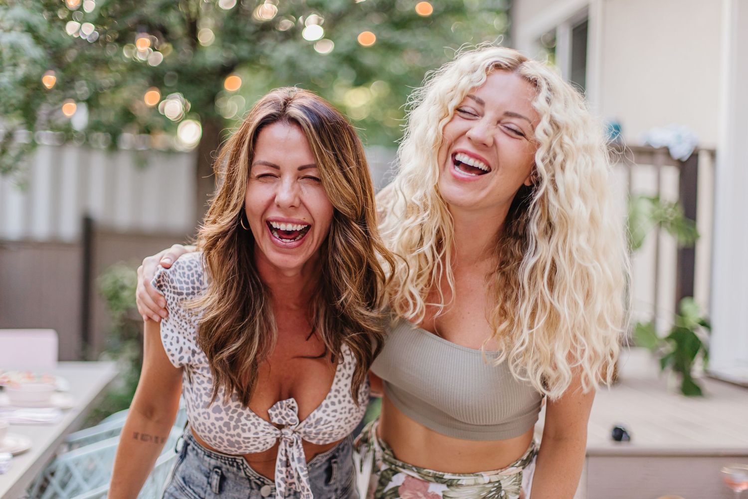 Two friends sharing a joyful moment outdoors with natural lighting.