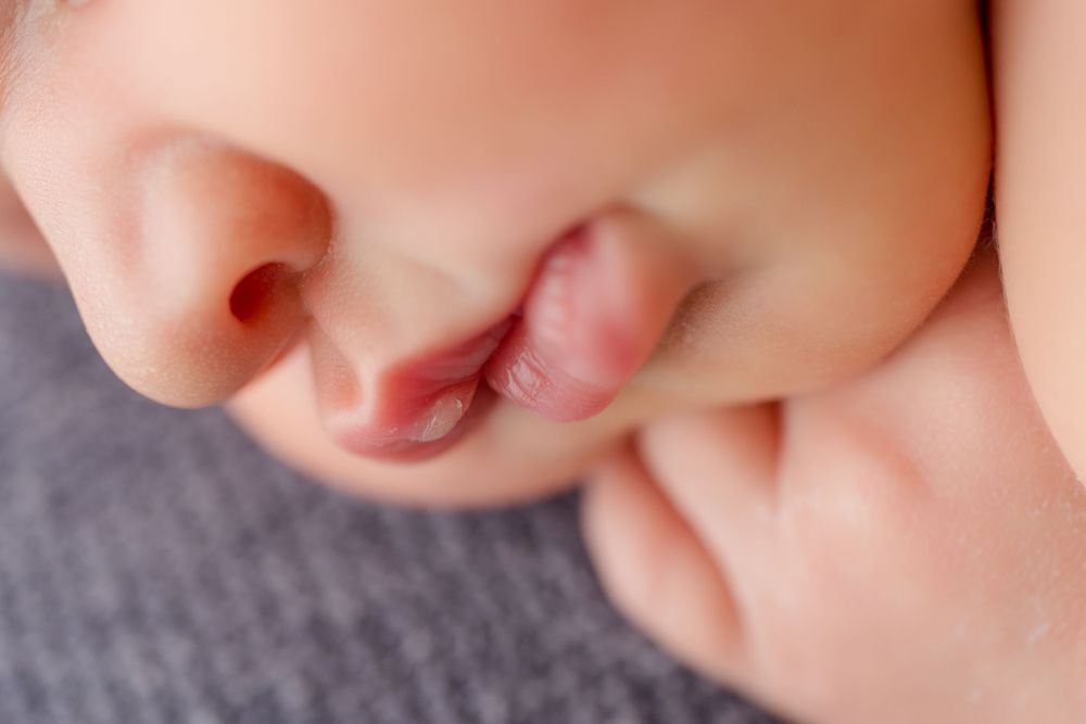 Artistic macro photograph of a sleeping newborn's facial features.