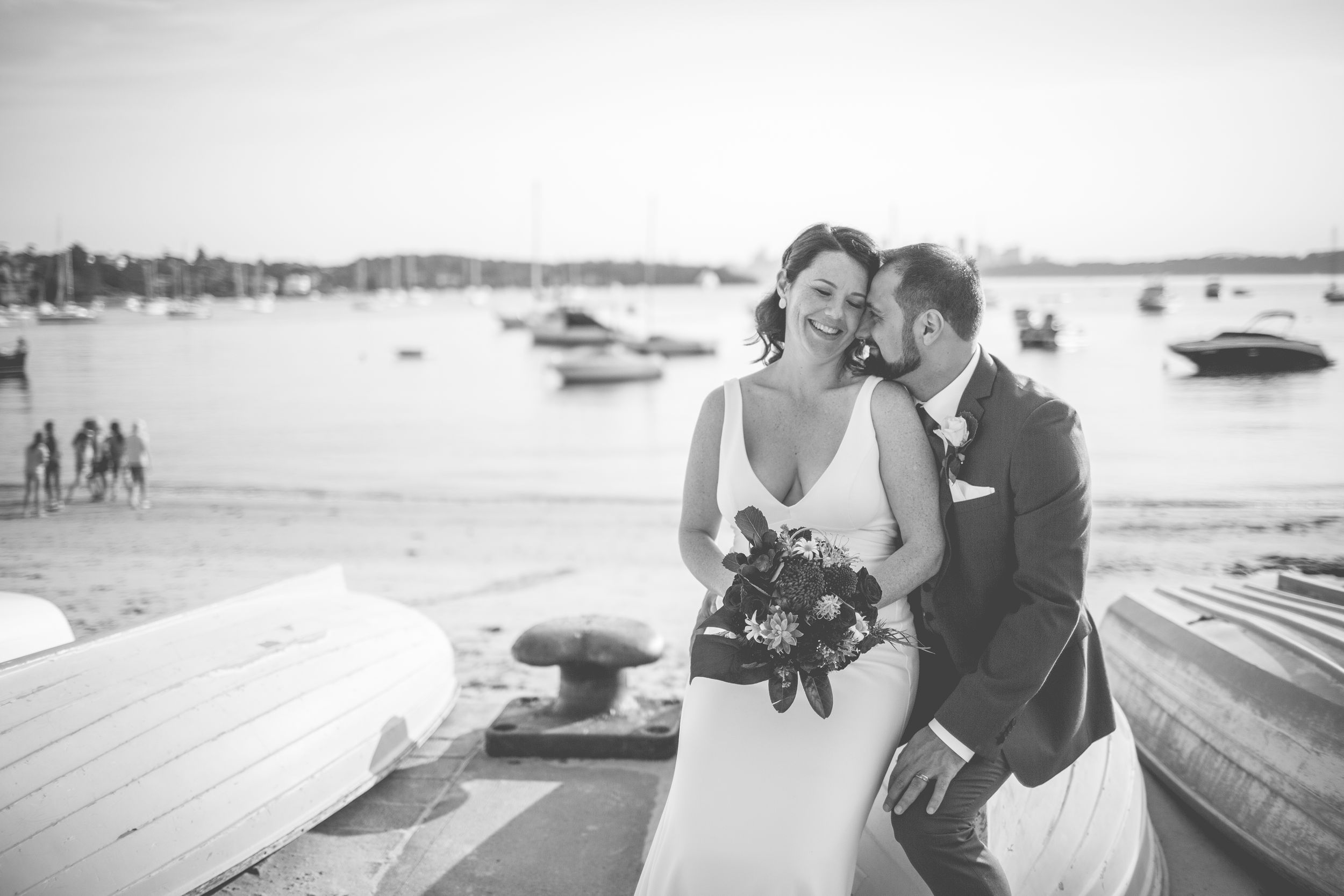 A waterfront wedding scene with boats in the harbor and a seaside celebration.