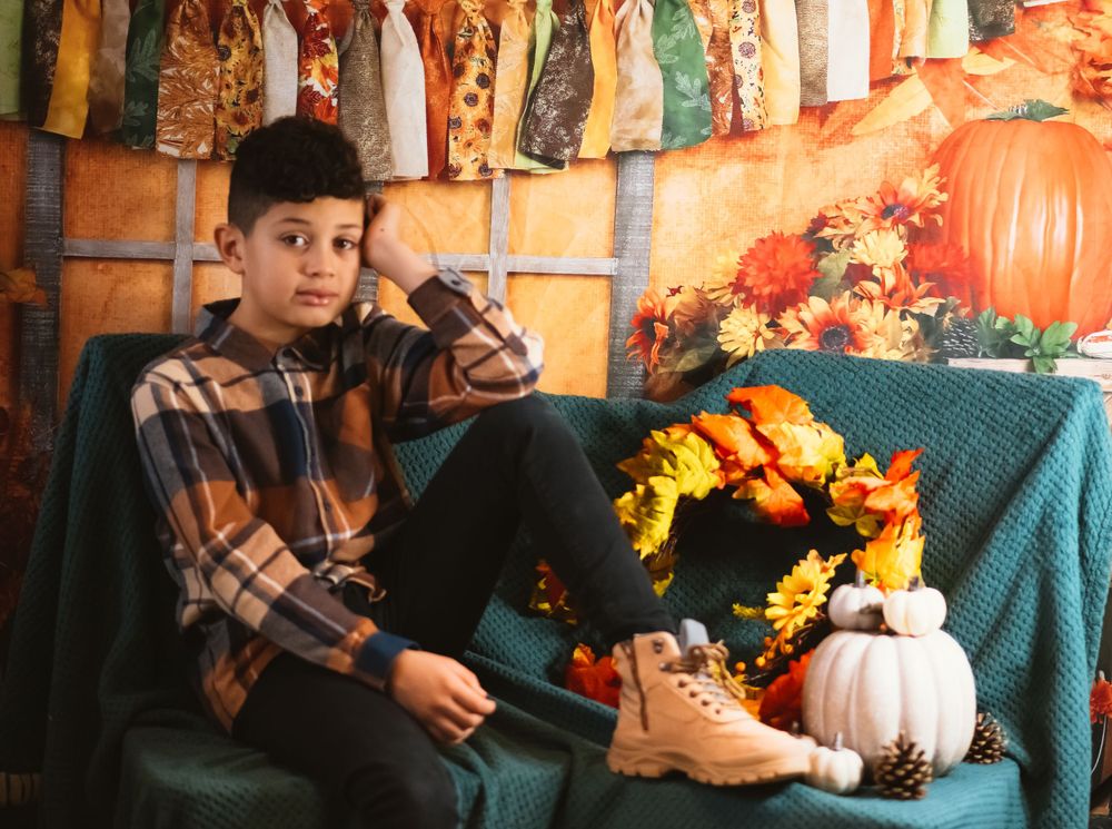 Autumn themed portrait with pumpkins and fall decor on teal couch.