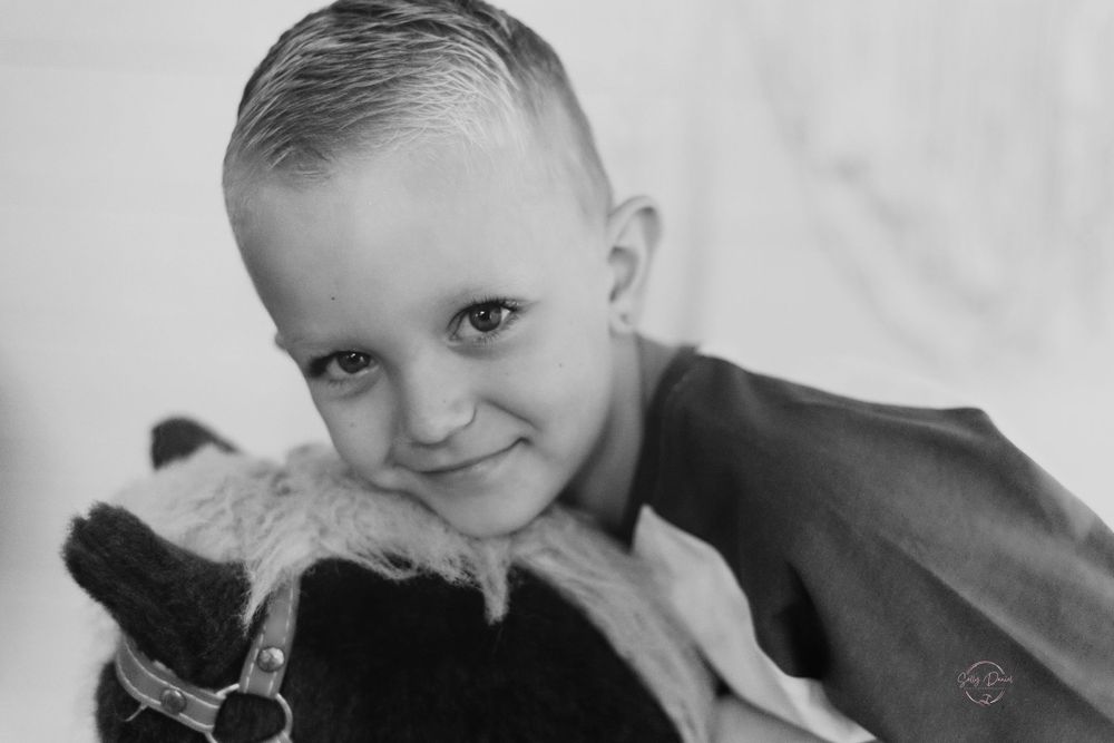 Black and white portrait of a young child and furry companion.