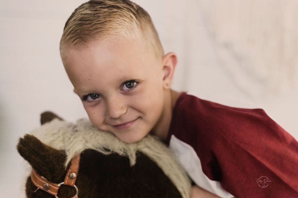Color portrait of a young child with a fluffy pet.