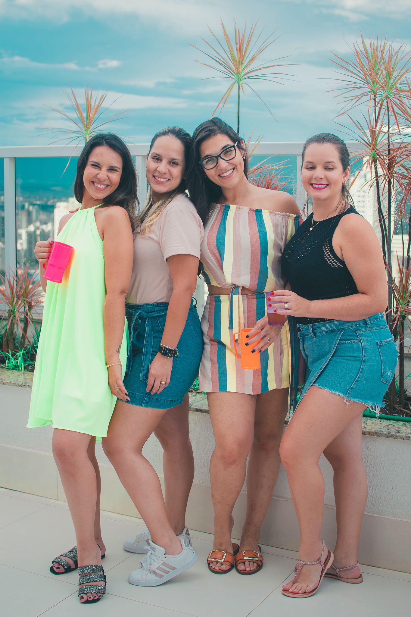 Group photo on a sunny rooftop terrace wearing colorful casual summer attire.