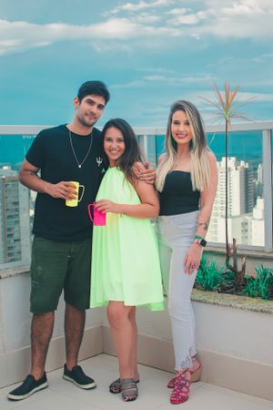 Social gathering on a high-rise balcony with city views and neon colored clothing.