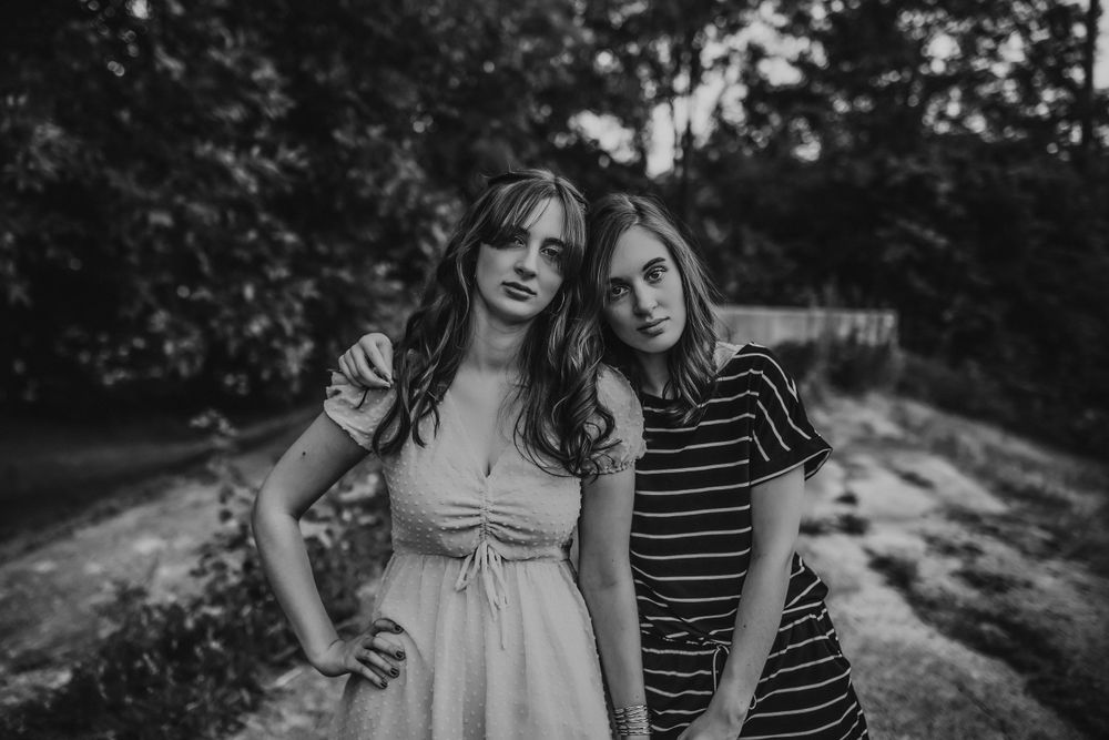 Couple poses together on a wooded path during an outdoor photo session.