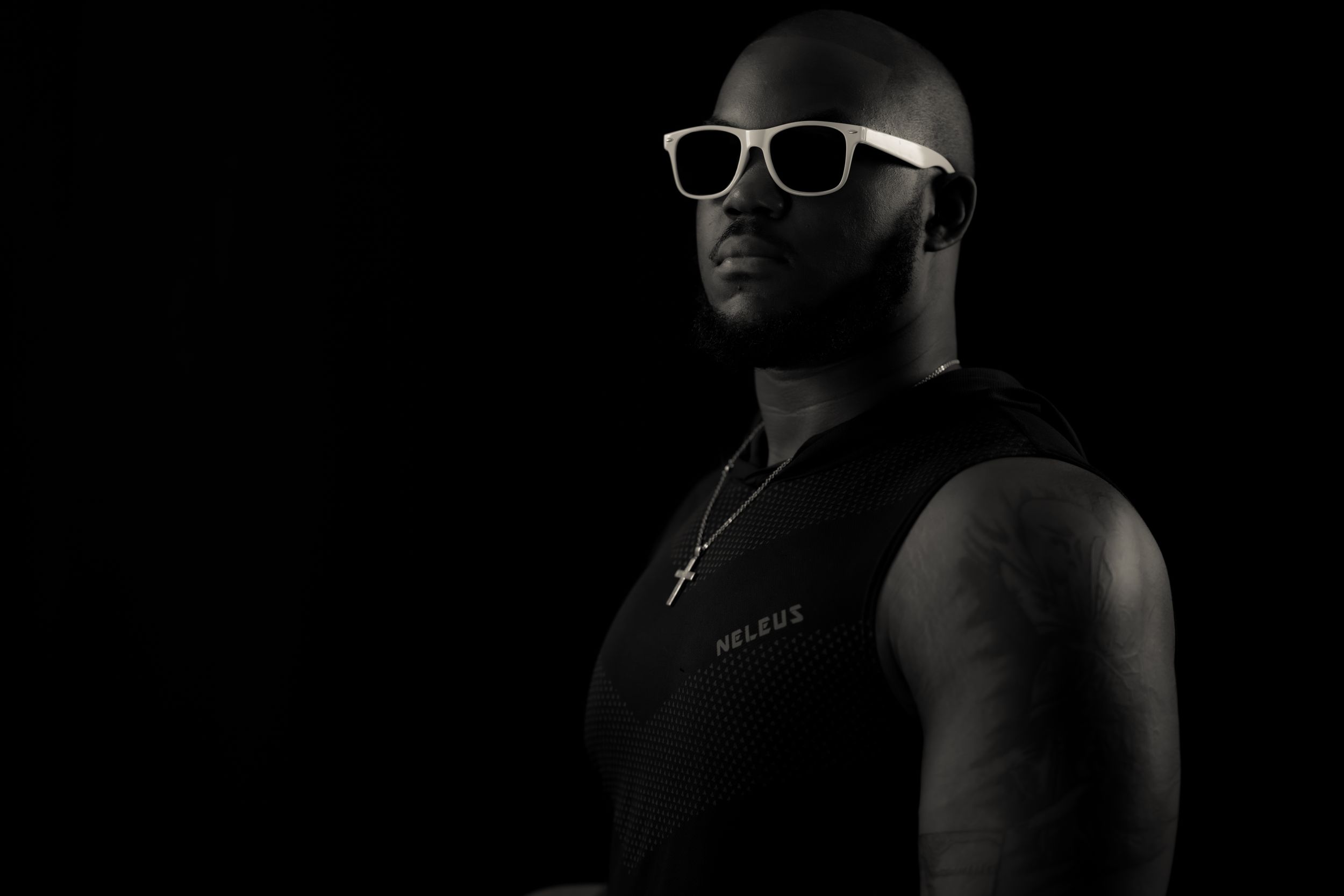 Dark artistic photo focusing on white-rimmed glasses and facial features.