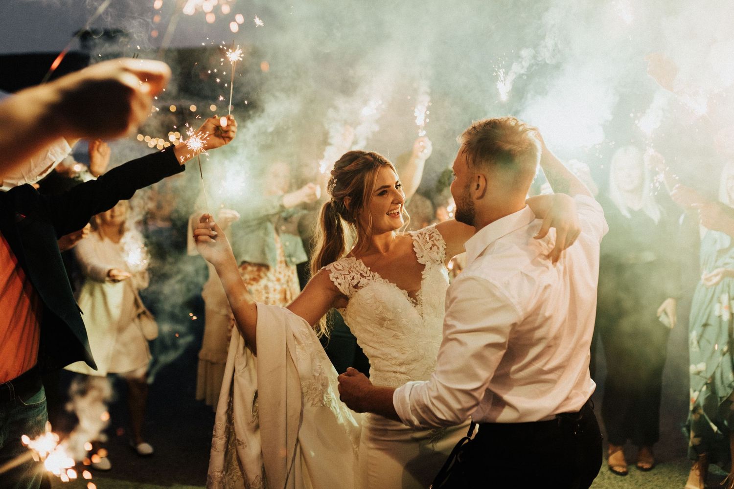 Wedding celebration with sparklers creating magical light effects during an evening reception.