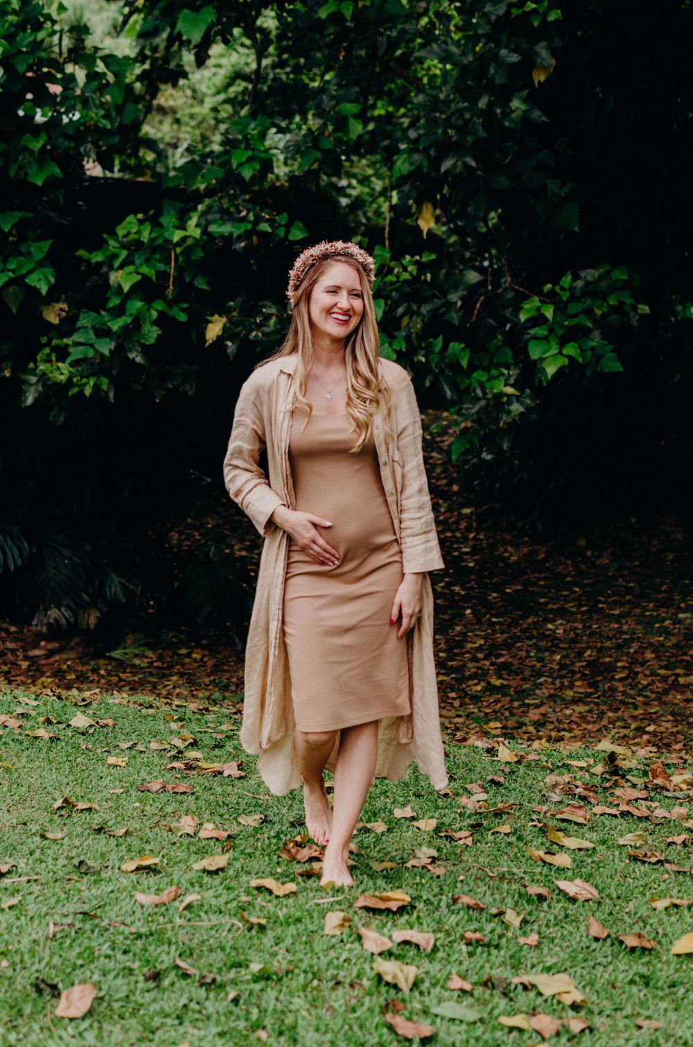 Outdoor maternity photography featuring neutral tones and natural garden backdrop.