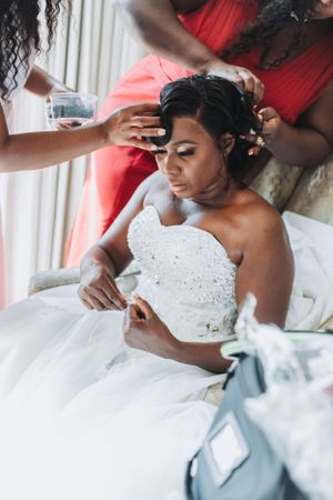 A bride in a stunning white beaded gown getting her final touches before the ceremony.