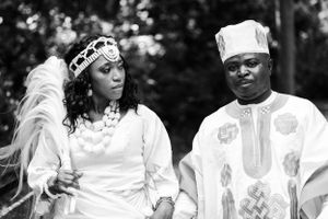 A black and white portrait of a couple in traditional African ceremonial dress.