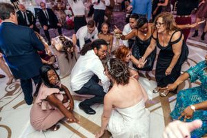 Wedding guests gather in a circle around the dance floor during a lively celebration moment.