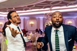 Two guests share an animated moment on the dance floor at an elegant reception venue.