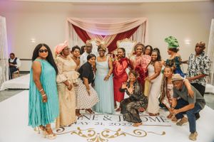 Wedding guests gather for a group photo on decorated reception floor.