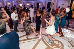 Guests dancing and celebrating at a wedding reception with decorative floor patterns.