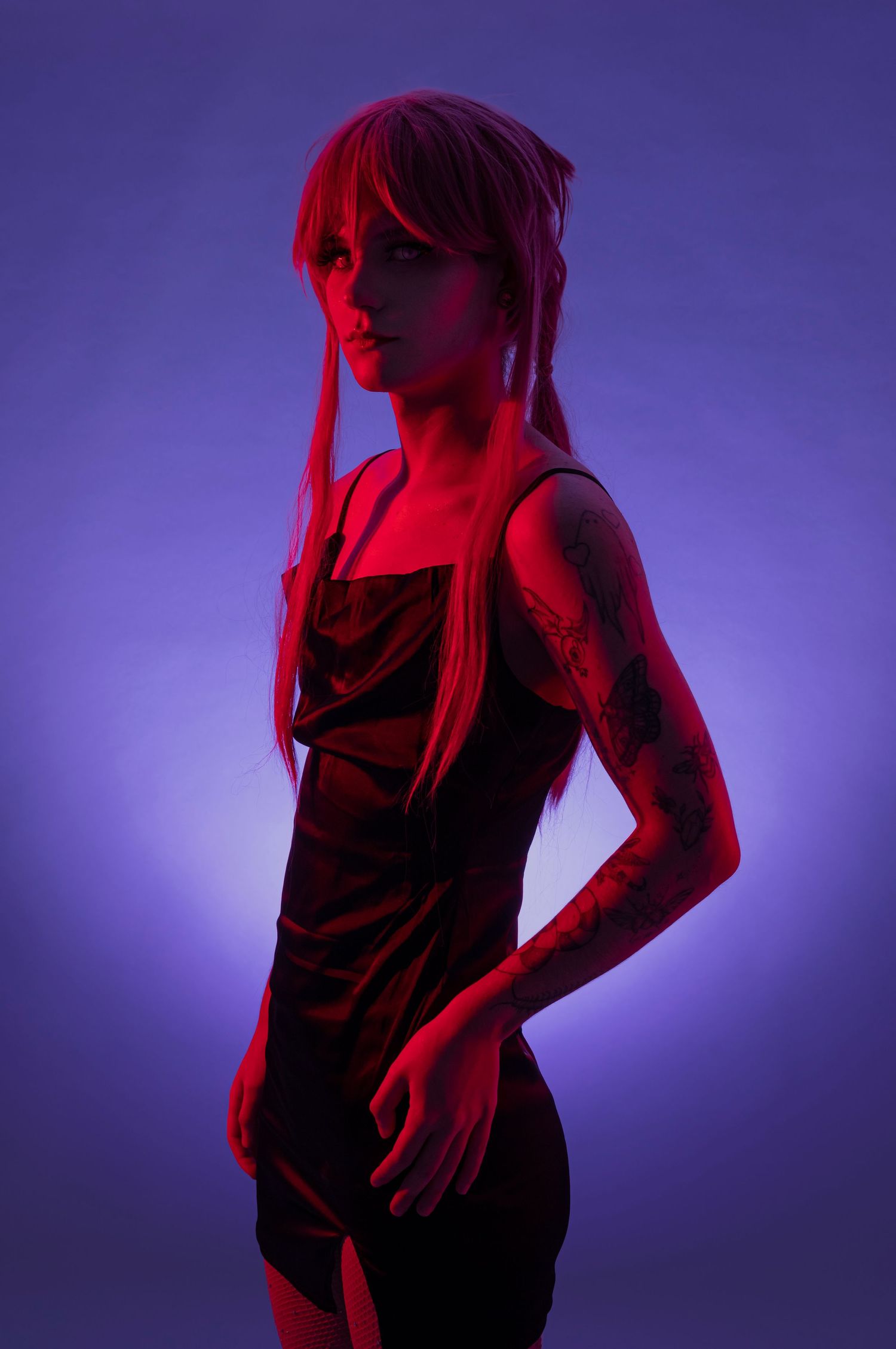 Moody fashion portrait with red and purple lighting effects.