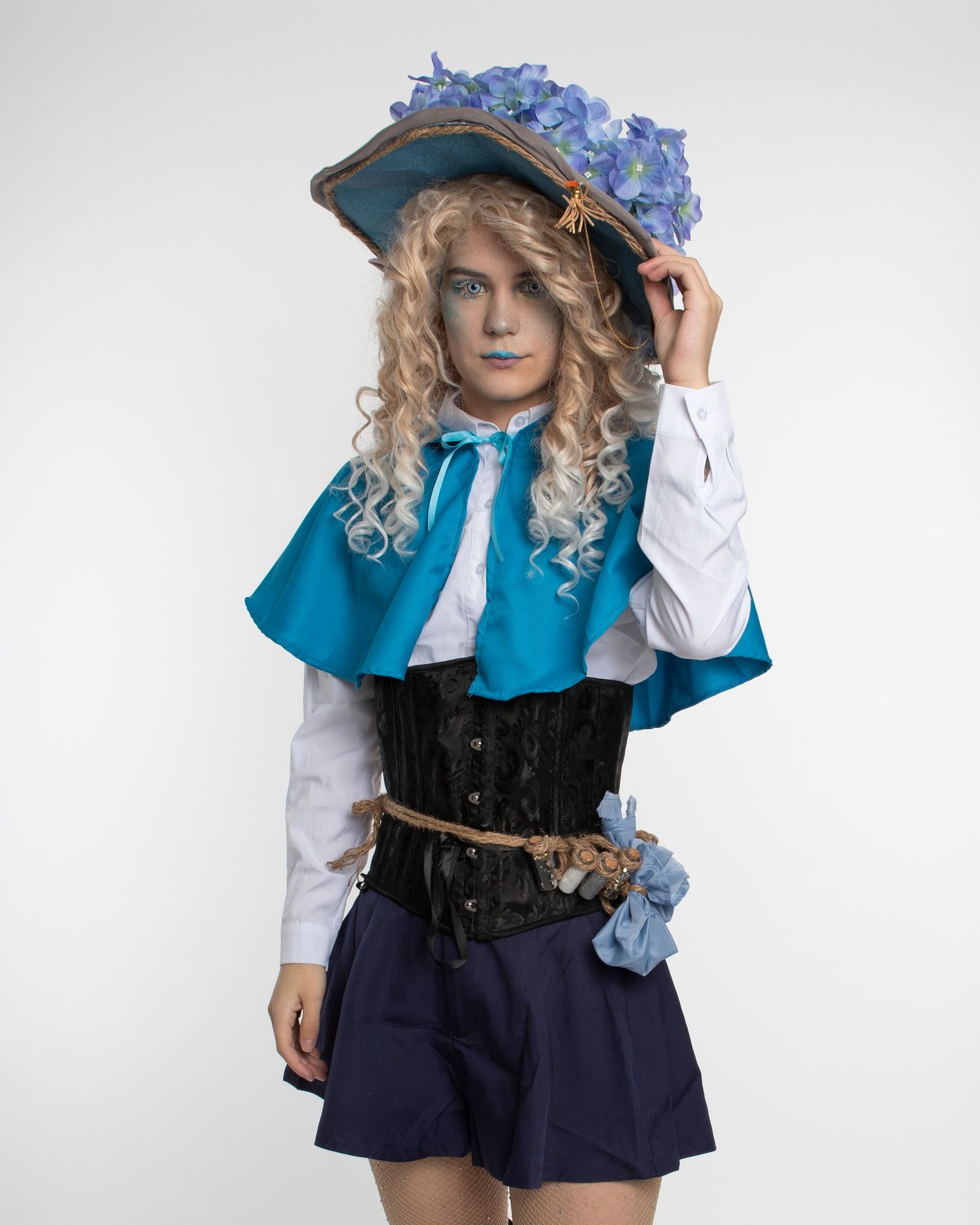 Cosplay costume featuring blue cape, corset, and floral hat in Victorian style.