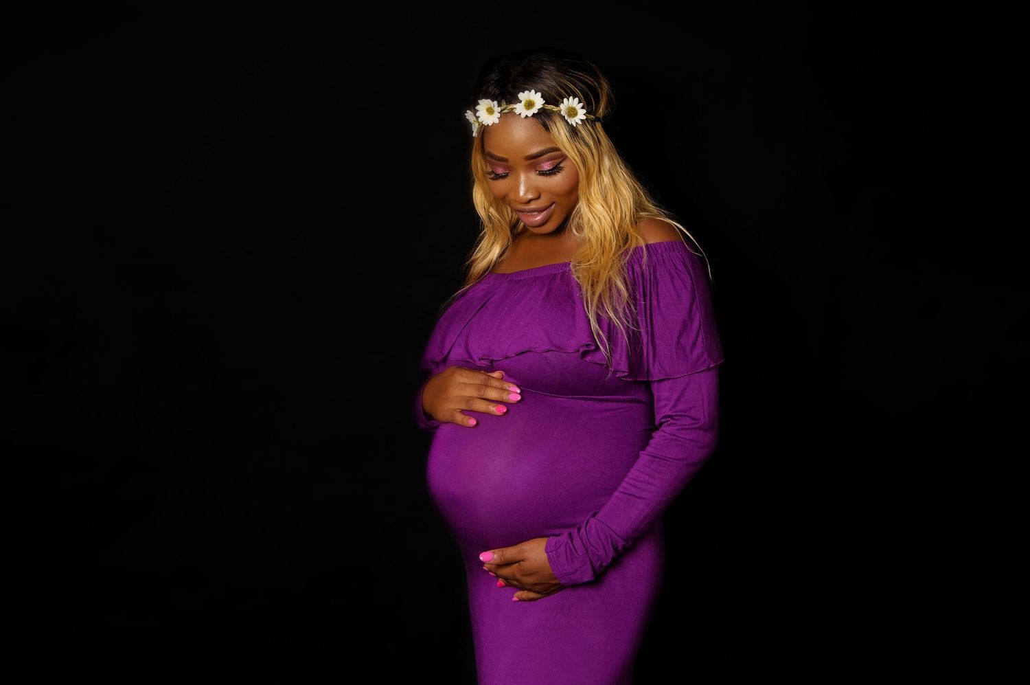 woman in studio embracing pregnant belly