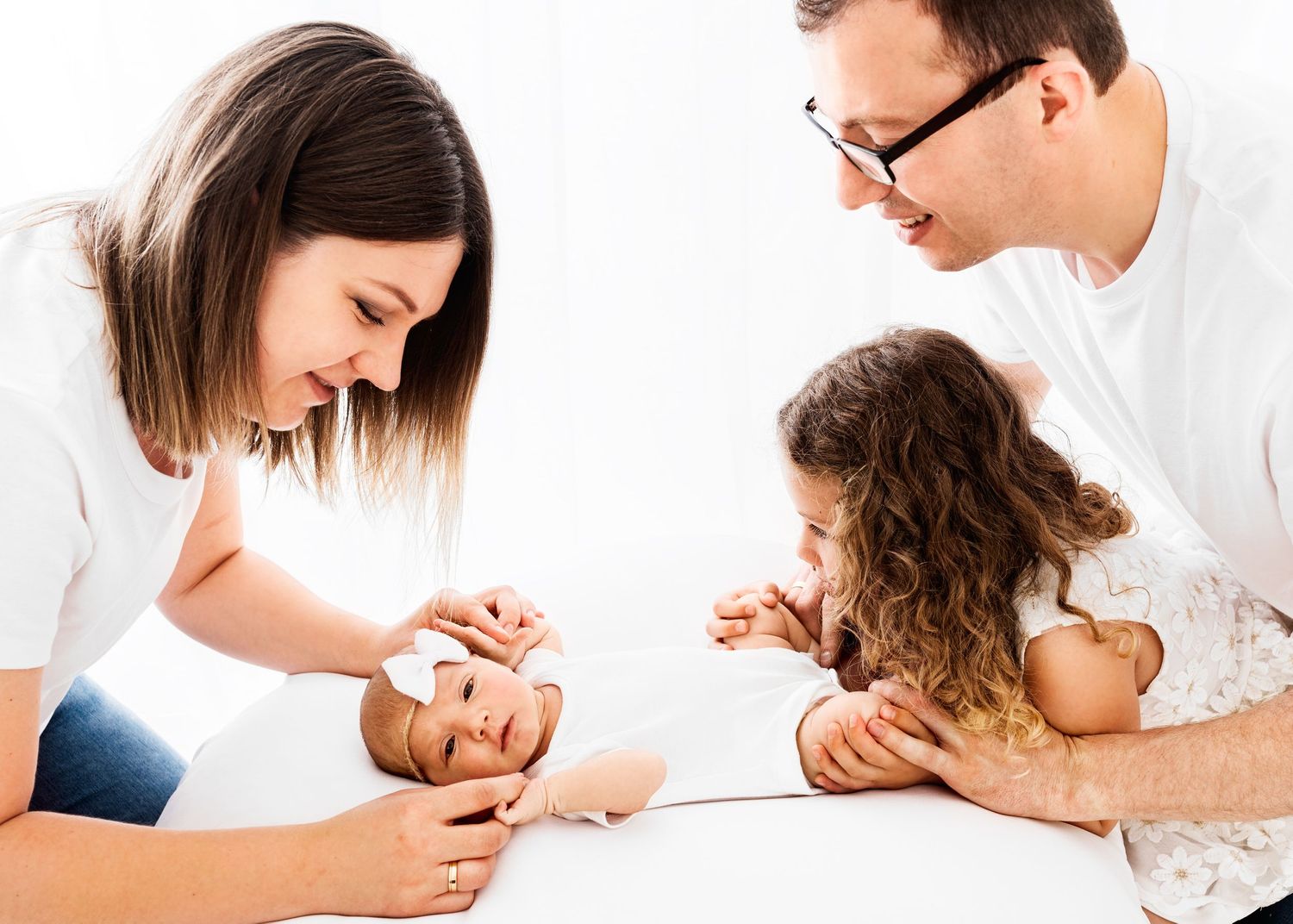 baby lead photo shoot with family in all white studio