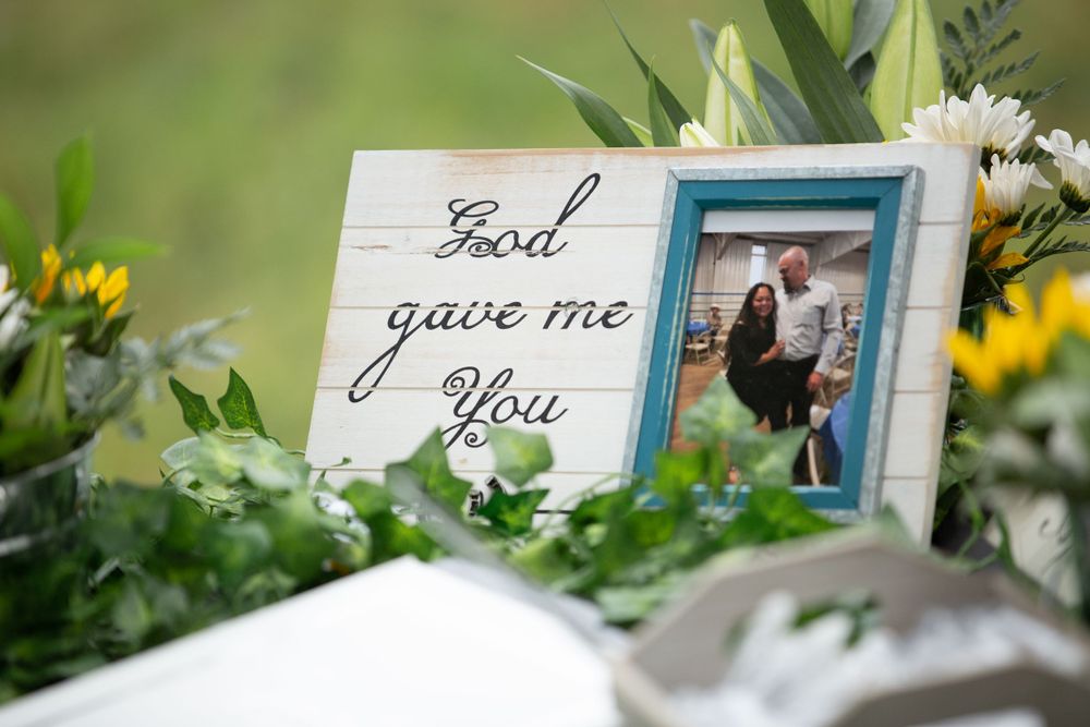Wedding decor with God Gave Me You sign in blue frame surrounded by yellow and white flowers.