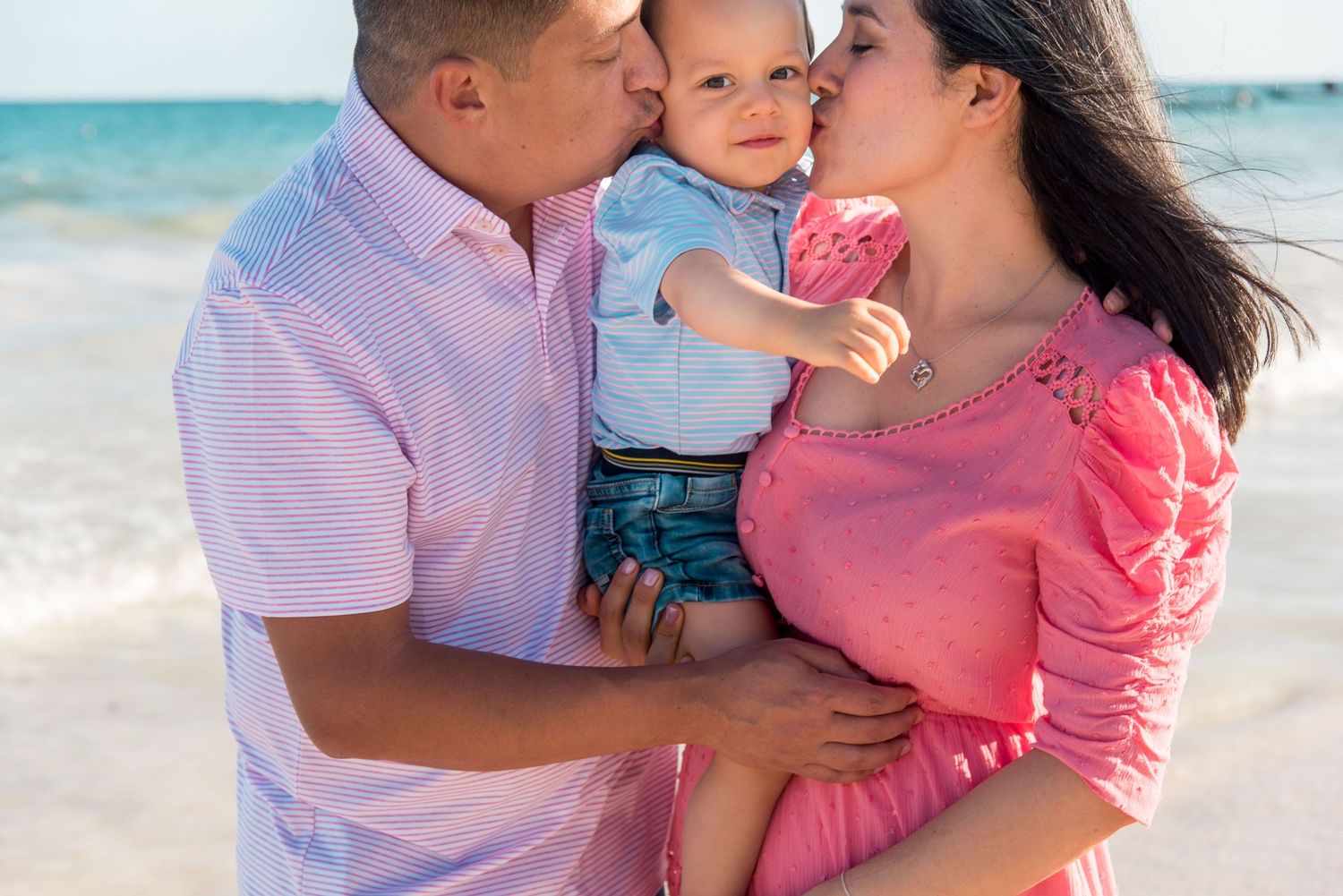 Evelyn, Roberto, and their son Rodrigo posing together at Playa Paraiso in Tulum, Mexico
