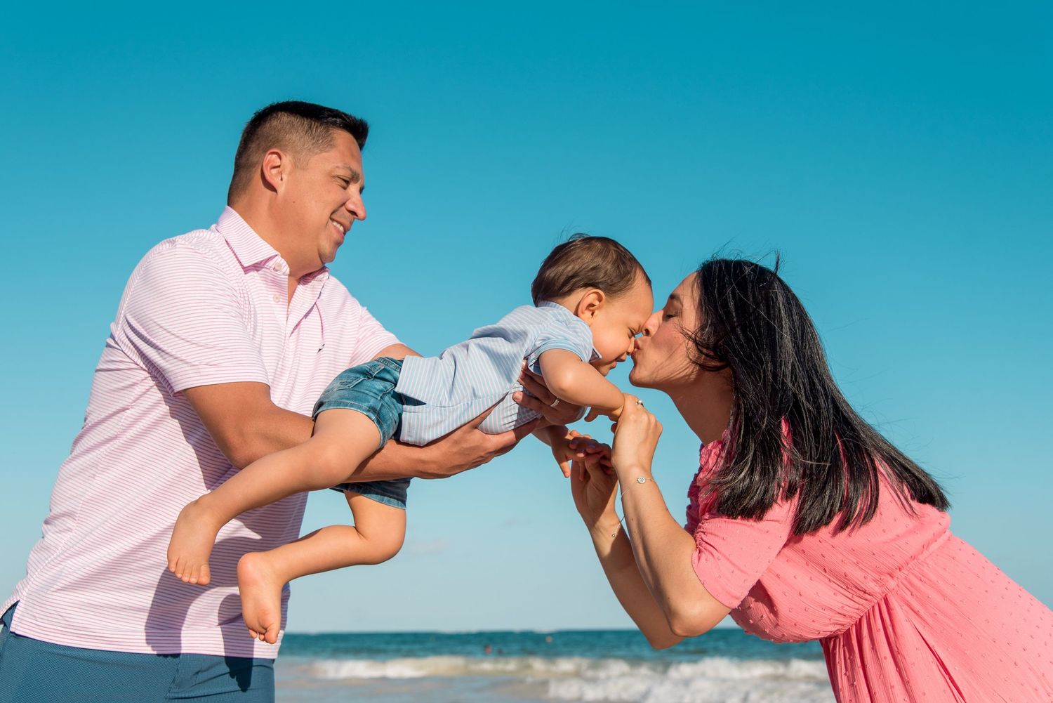Mom and dad playing with Rodrigo during their family photo session in Tulum
