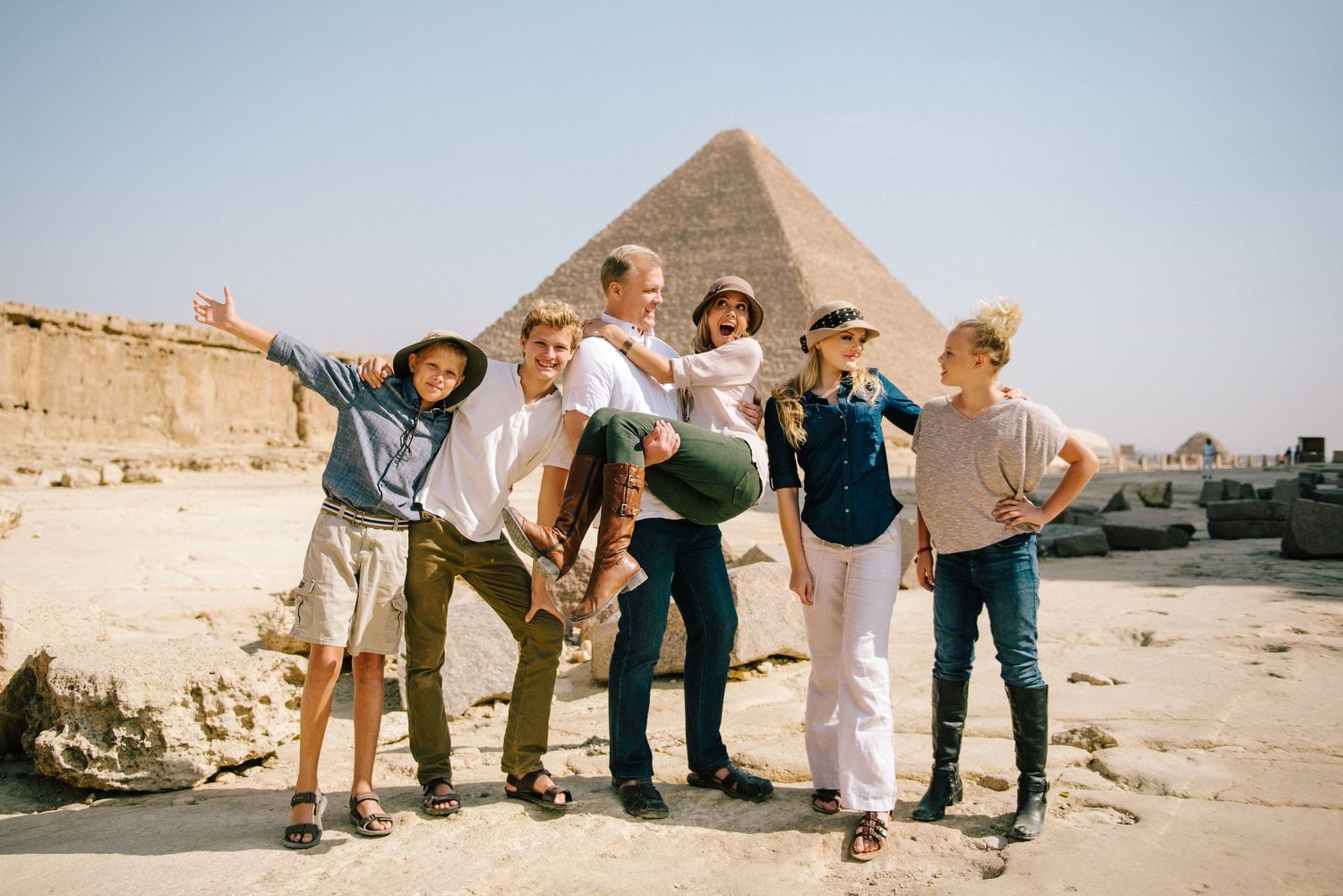 Group poses playfully together in front of the Great Pyramid of Giza in Egypt.