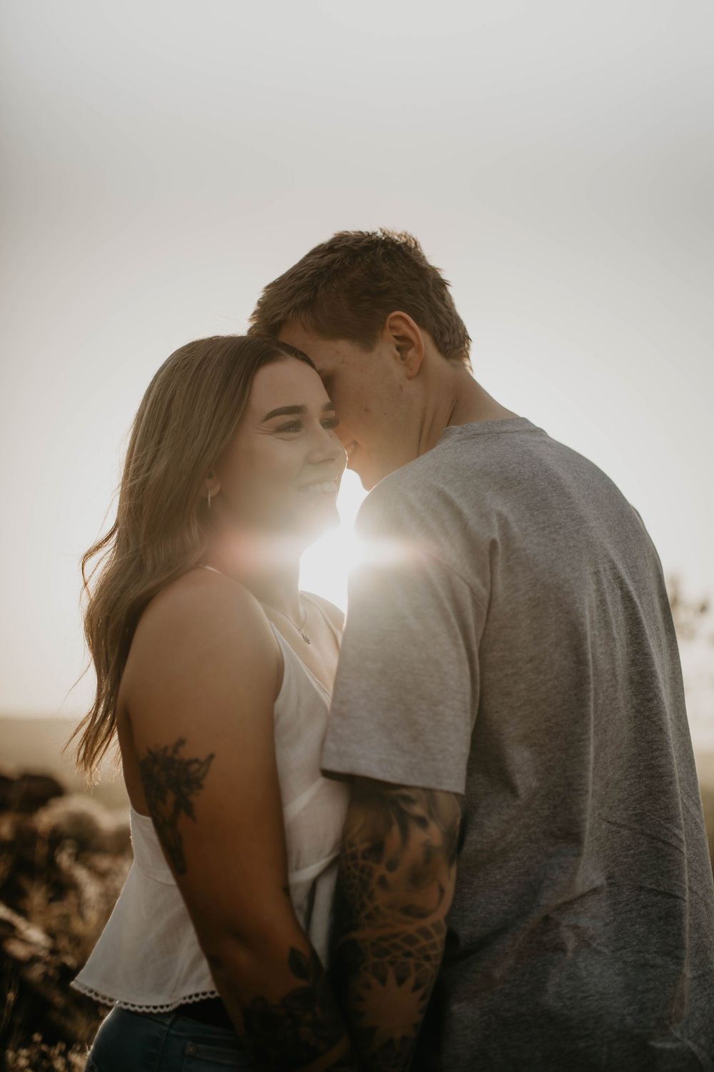 Couple standing with sunset between them in Mount Isa