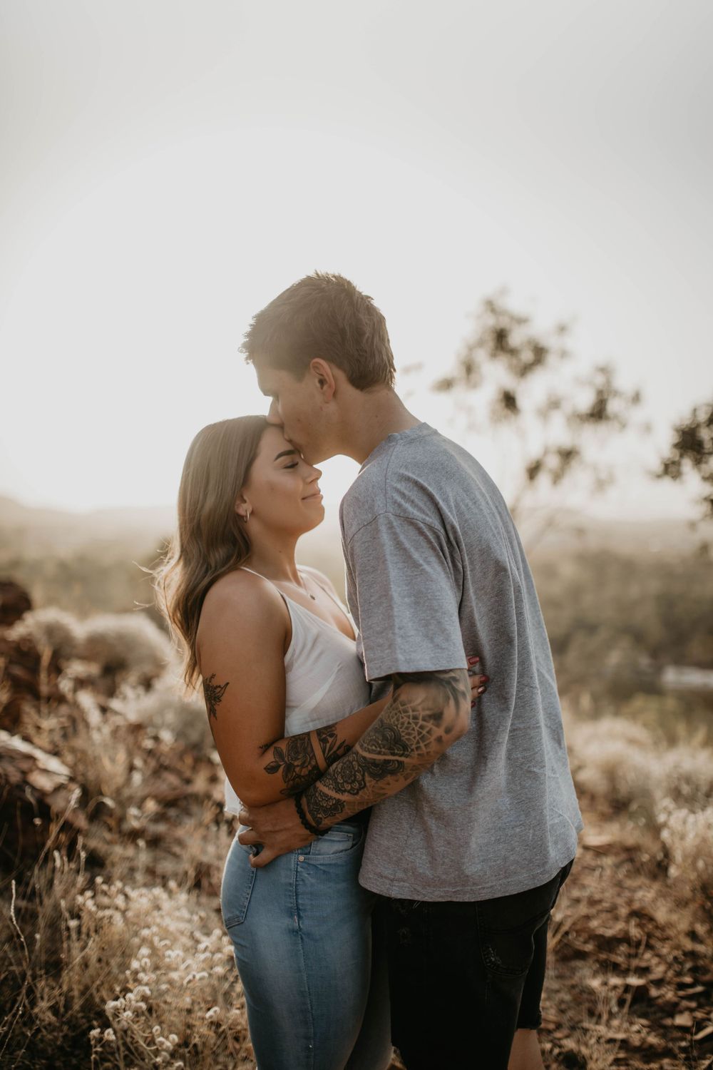 Man holding womans waist while kissing her forehead in Mount Isa