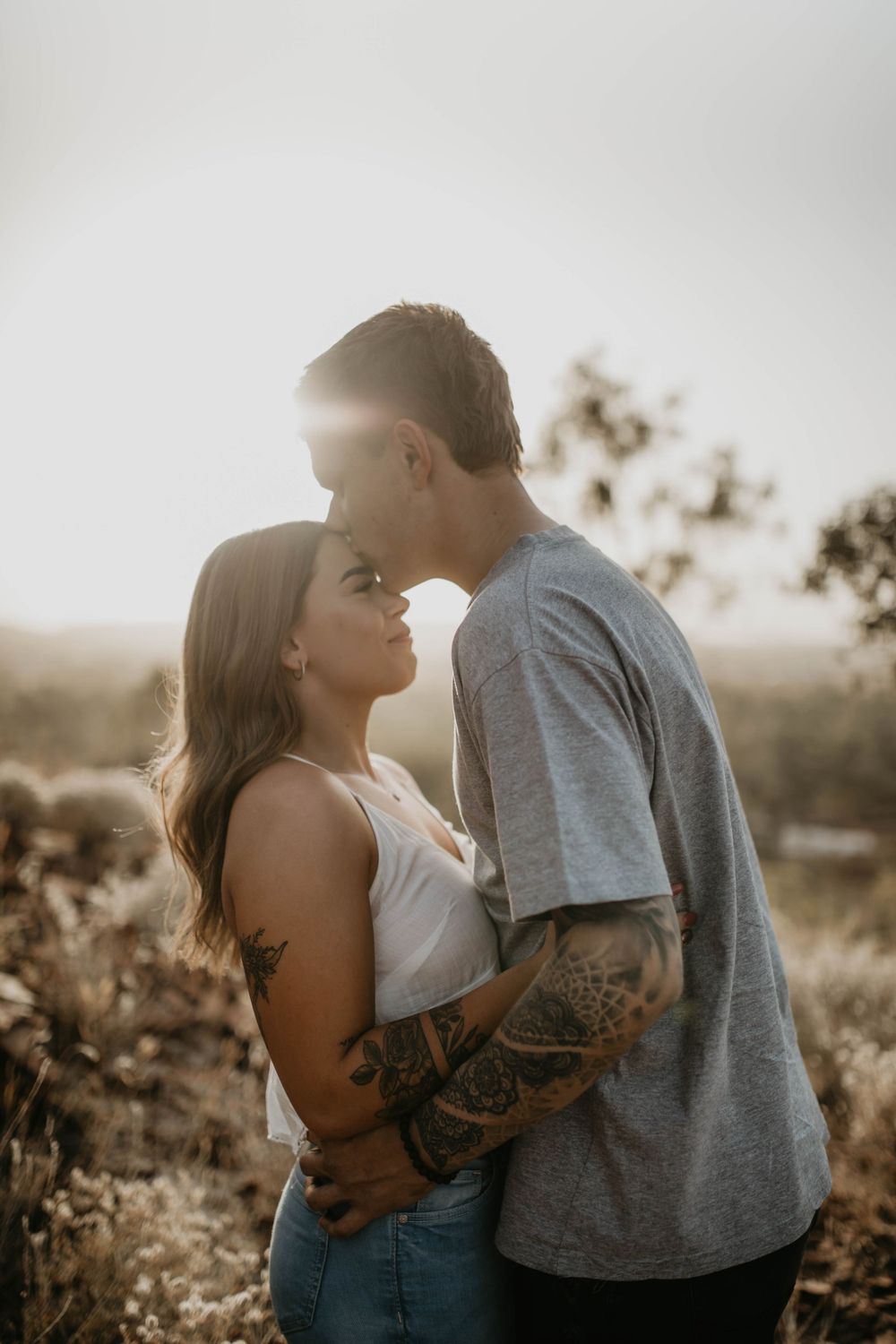 man kissing womans forehead on hill in Mount Isa