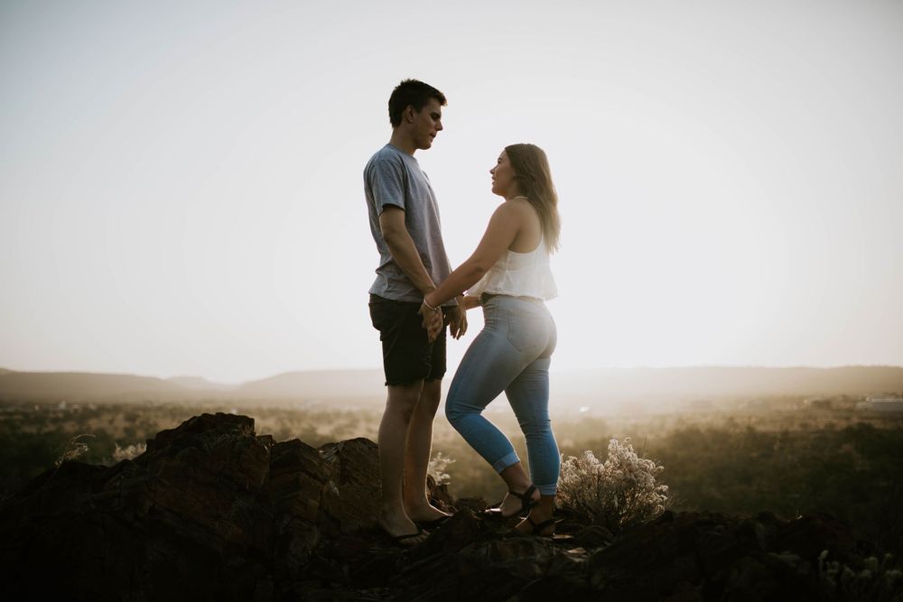Couple holding hands with sunsetting behind them in Mount Isa