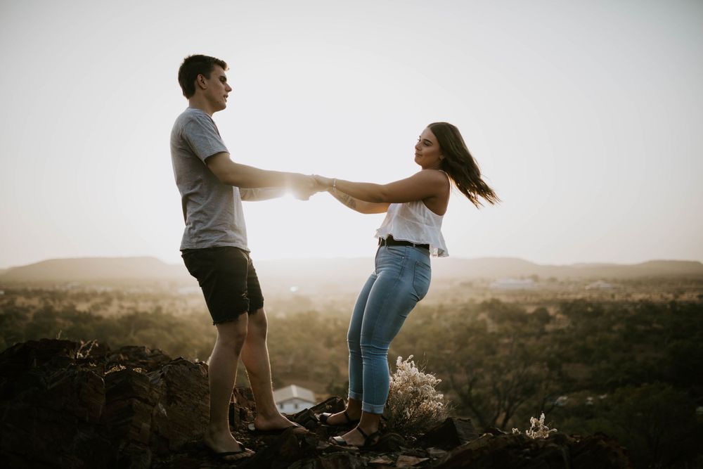 Couple holding hands arms apart in Mount Isa