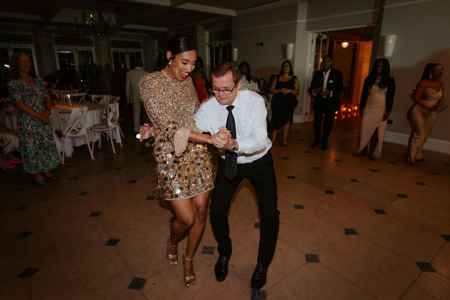 Dancing at a reception in a sparkling dress as the party gets lively.
