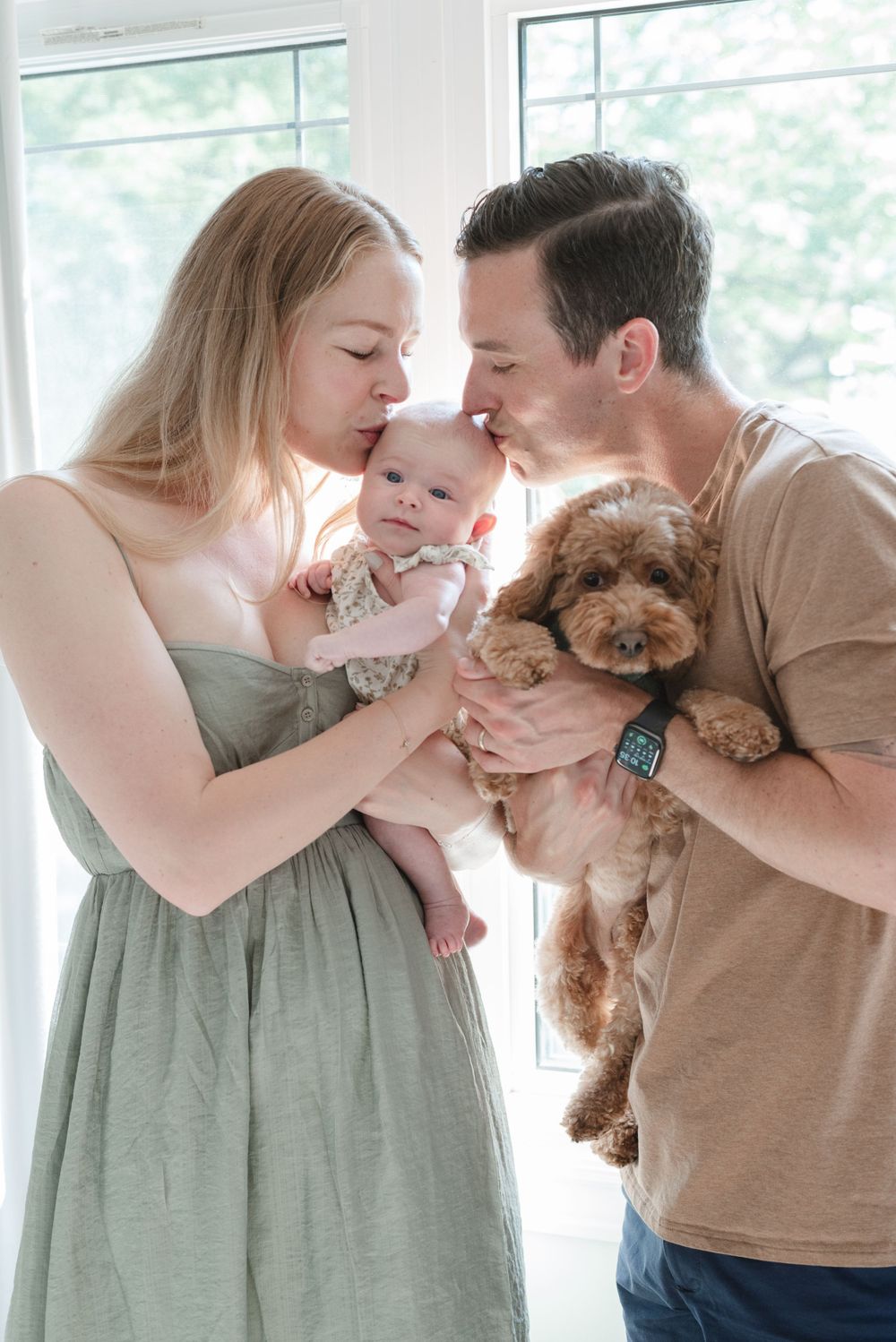 Toronto family in Light and airy outfits for a lifestyle newborn session in home, holding baby and dog. Captured by Jess GC Photography