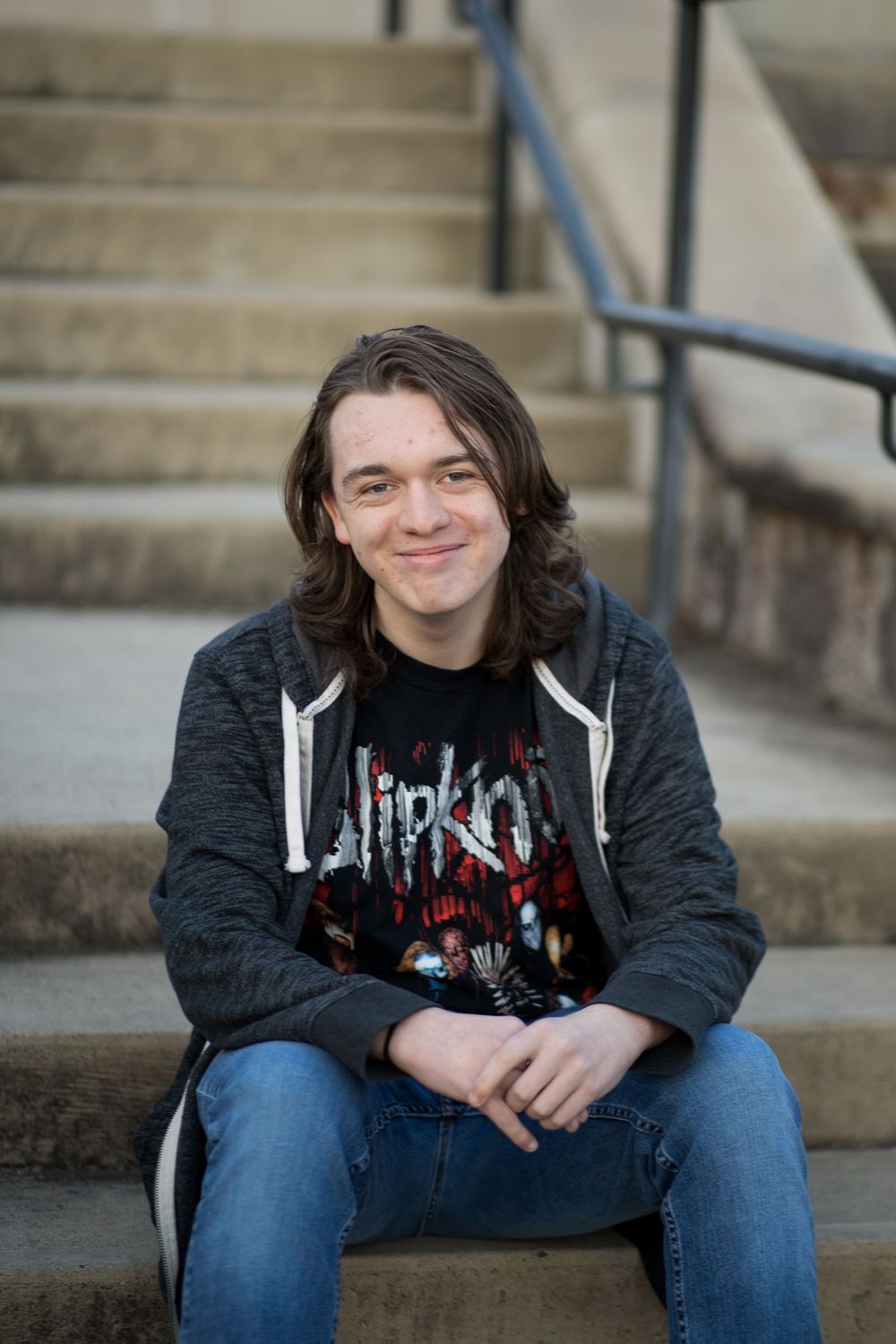 High school senior sitting on steps smiling