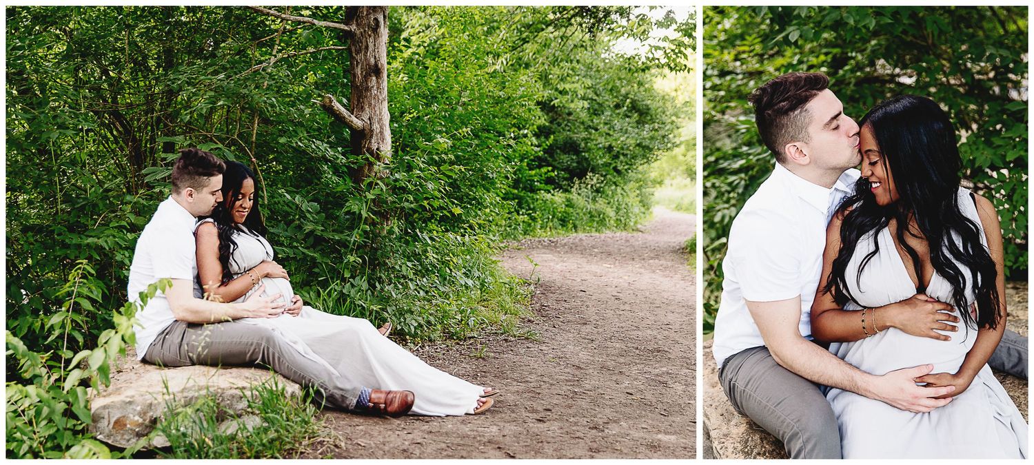 couple sitting in nature park cuddled together man kissing woman's forehead
