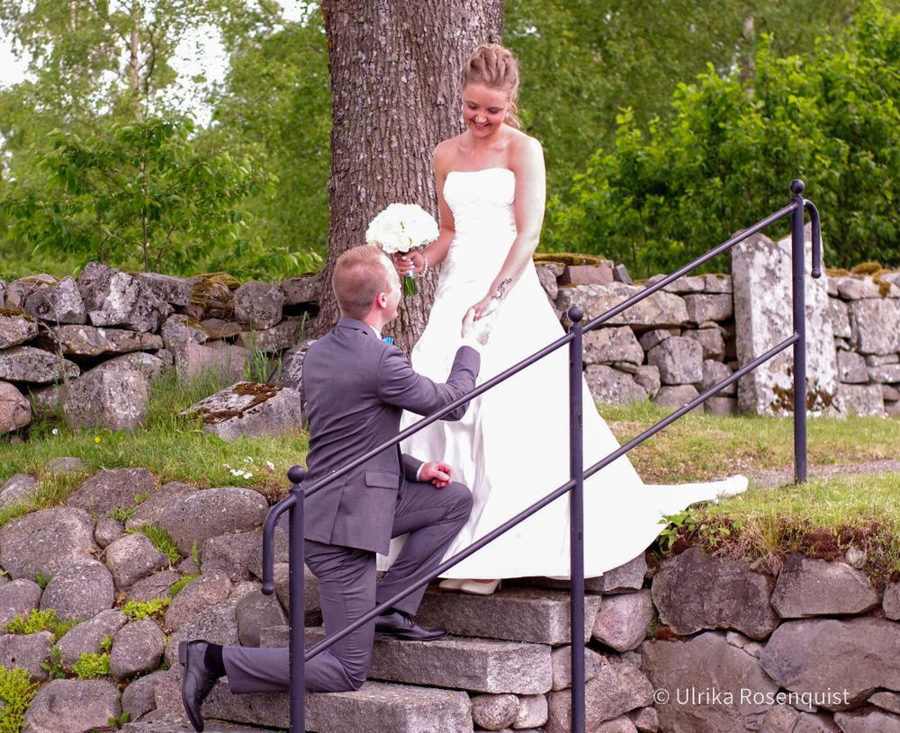 A touching moment on stone steps during a wedding photoshoot.