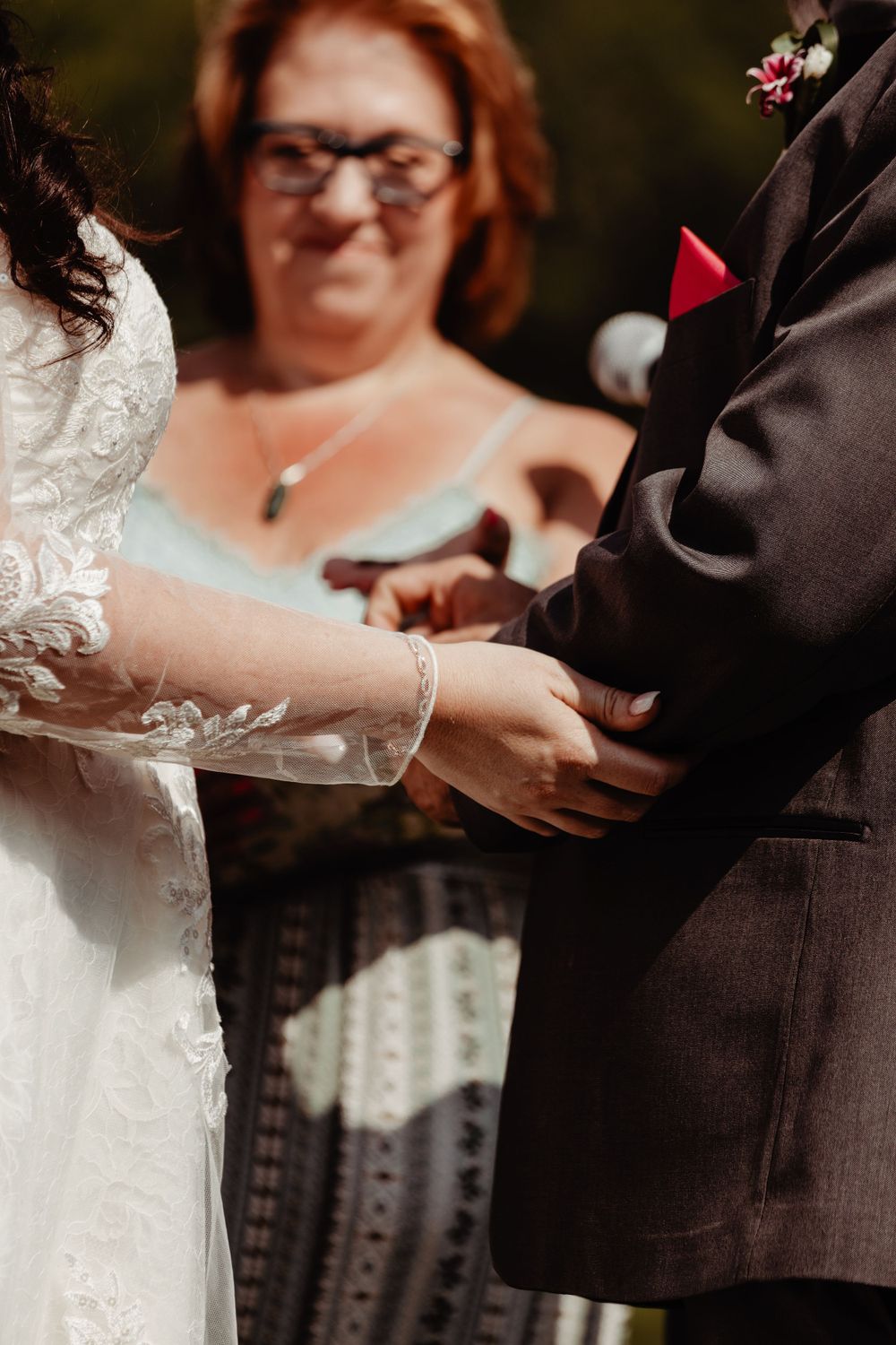 A close-up shot of hands exchanging rings during a wedding ceremony.