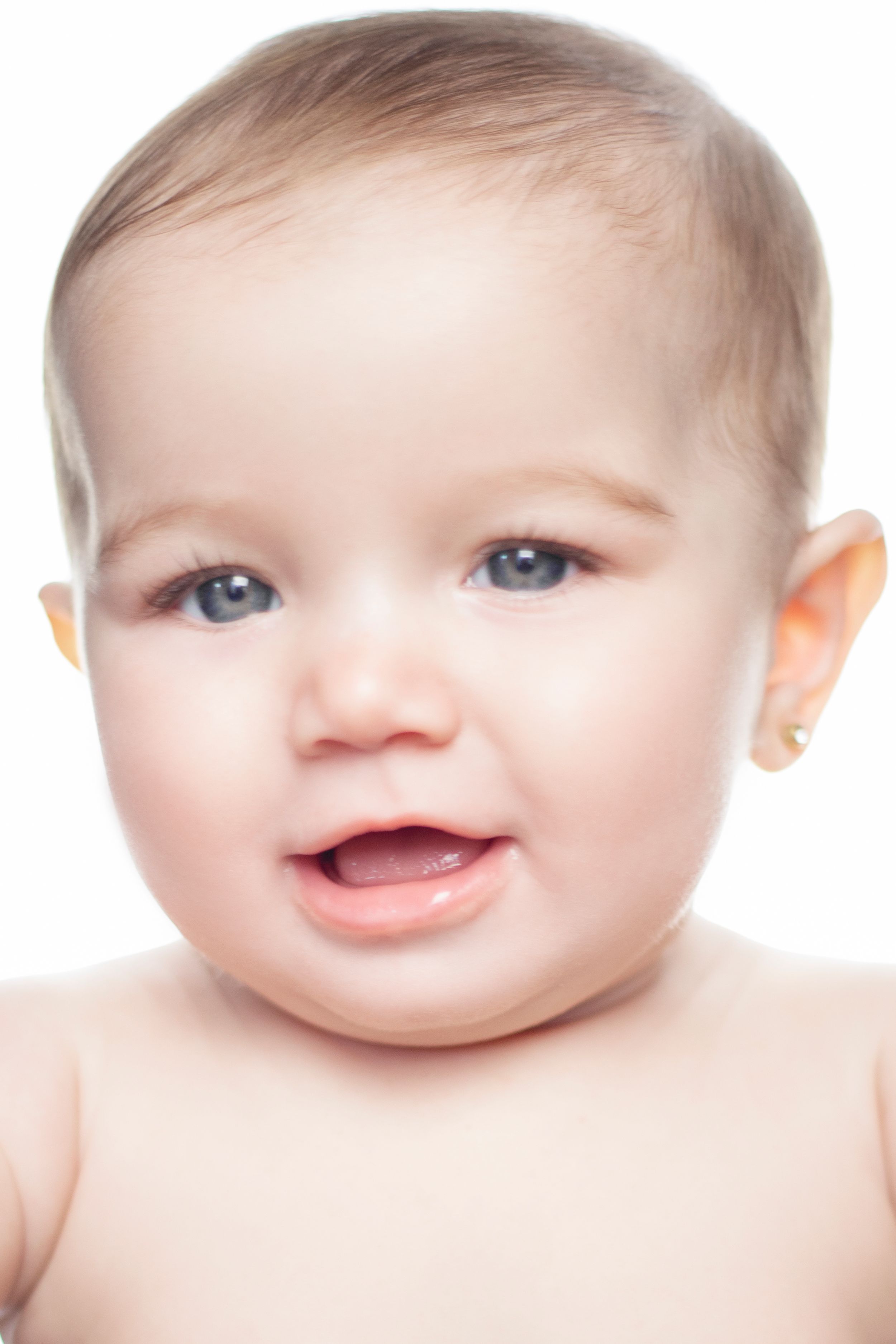 Close-up studio portrait showing bright smile against white background.