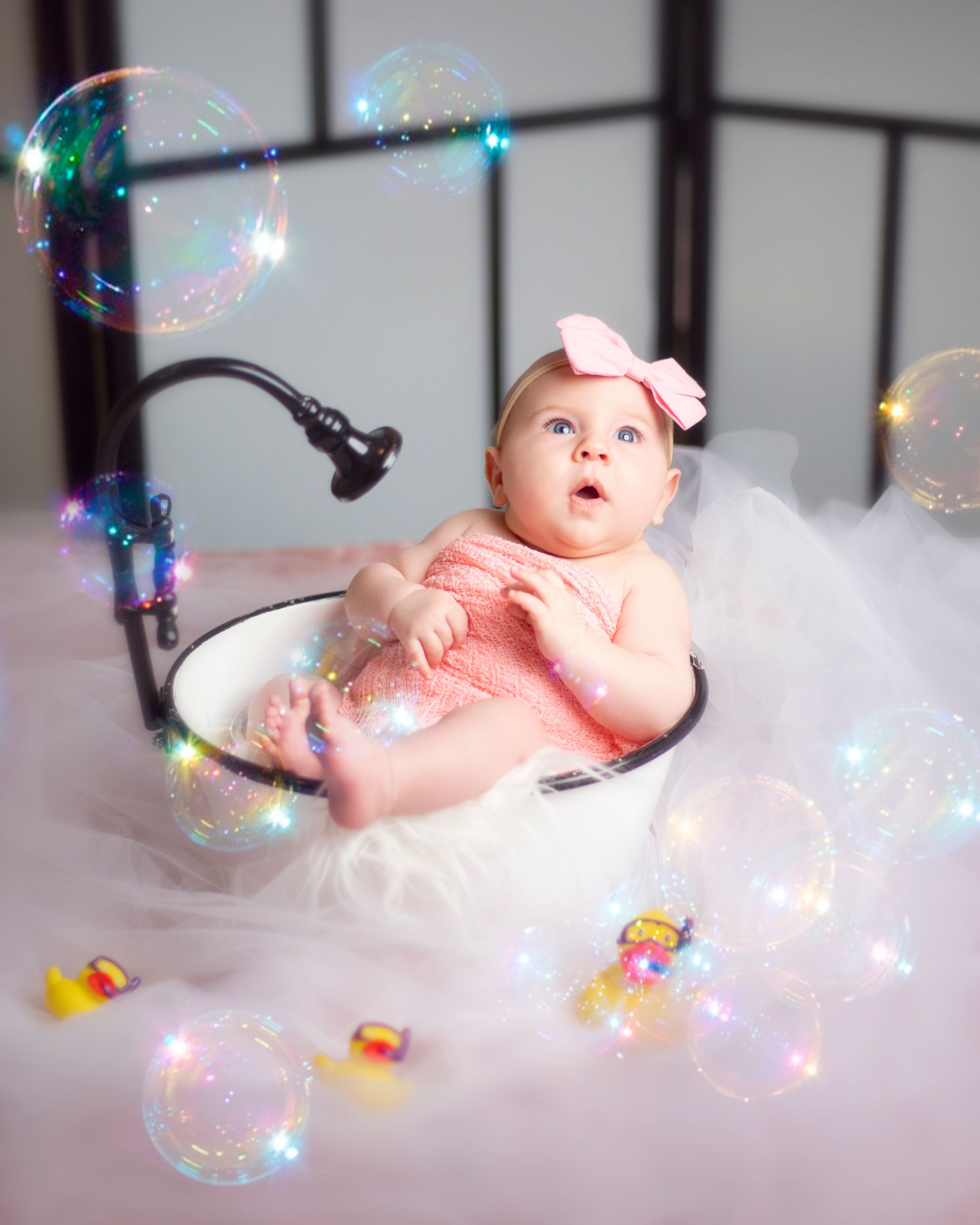Whimsical baby portrait with twinkling lights and soap bubbles in a dreamy setting.